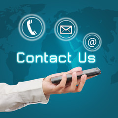 Business hand showing smartphone with  word contact us and icon