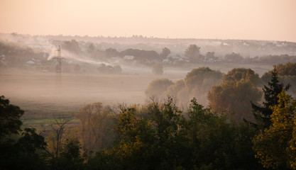 sunset with fog and smoke and sun rising over village