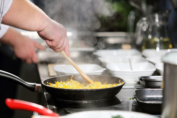 Cook stirring food in a pan