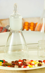 image of pills on a plate, vial and flasks closeup