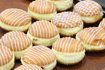 Glazed donuts with jam on a tray