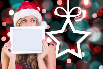 Composite image of festive blonde showing a tablet