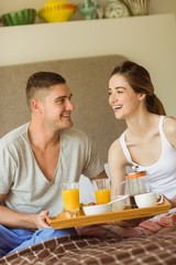 Obraz na płótnie Canvas Cute couple having breakfast in bed