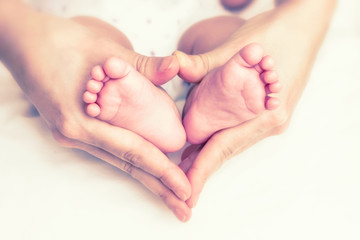 Obraz na płótnie Canvas Baby feet in the mother hands