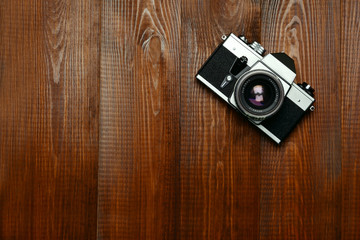 Old camera on wooden background.
