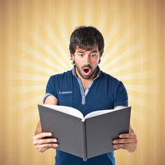 Man reading a book over pop background