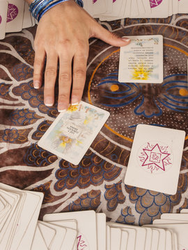 Mano de mujer junto a cartas de Tarot. Vista superior