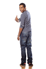 smiling dark-skinned young man in jeans showing thumbs up
