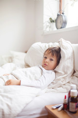 Obraz na płótnie Canvas Sick child boy lying in bed with a fever