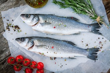 Two raw seabass with  cherry tomatoes and rosemary