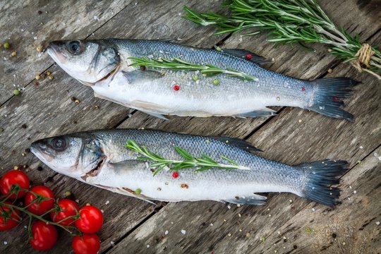 Two raw seabass with cherry tomatoes and rosemary