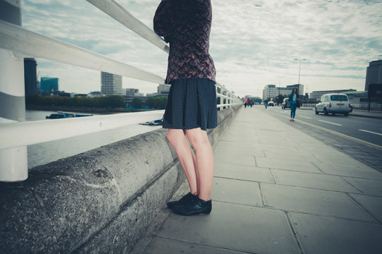 Young woman standing on bridge in city