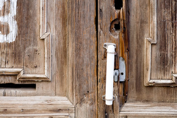 Rusty old cabin door handle in dusky light closeup.