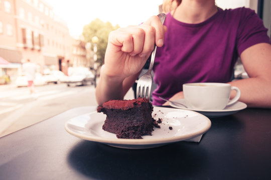 Young woman having coffee and cake
