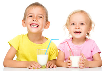 Cute little girl and boy are drinking milk