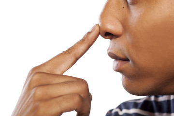 dark-skinned young man pressed his nose with his finger - obrazy, fototapety, plakaty