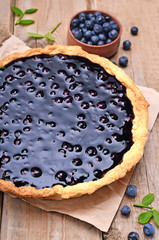 Blueberry pie and berries on wooden table