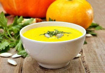 Pumpkin cream soup on wooden table