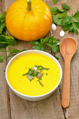 Pumpkin cream soup on wooden table