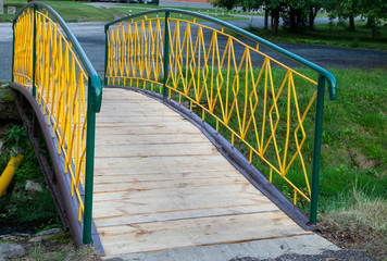 The cheerful yellow bridge over a stream