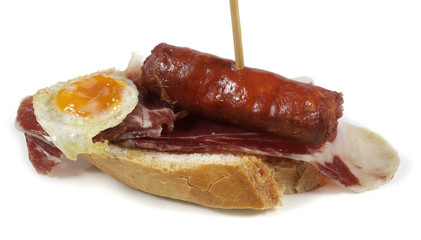 skewer with sausage, fried egg and ham