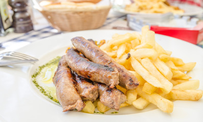 German sausages with french fries on a white plate