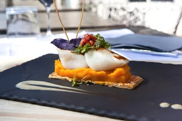Tuinposter Saint-Jacques scallops, carrots puree and biscuit on a slate © Redzen