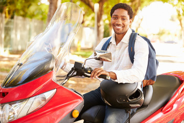 Young Man Riding Motor Scooter To Work