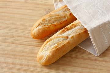 baguettes in a linen napkin on wooden background
