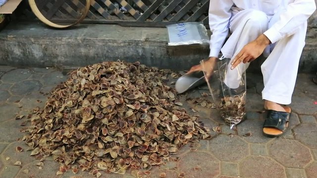 Man filling spices in polybags at spice market in Dubai