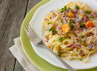 pasta in a creamy sauce with mushrooms on a wooden background