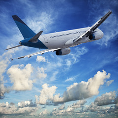 Fototapeta na wymiar Jet cruising in a blue cloudy sky