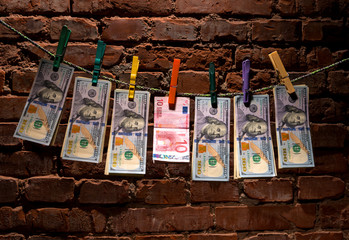 Dollar and euro bills  hanging on a rope