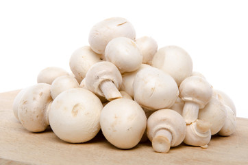 Fototapeta na wymiar Heap of fresh button mushrooms on a wooden board