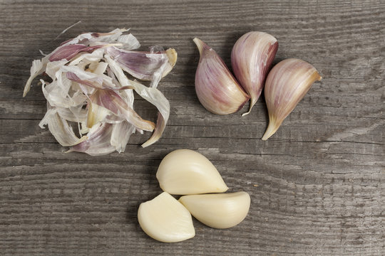 Garlic peeling on wooden plate top view