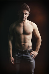 Fototapeta na wymiar Handsome shirtless muscular man on dark background