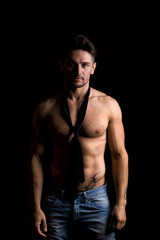 Fototapeta na wymiar Handsome shirtless muscular man standing on dark