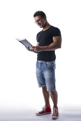 Full body shot of handsome man reading book on white