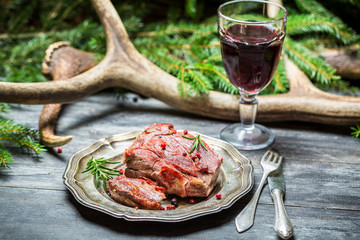 Red wine in a glass and venison on a plate - obrazy, fototapety, plakaty