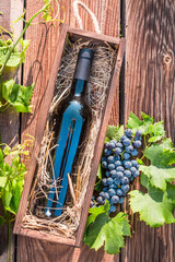 Red wine in a wooden box with hay