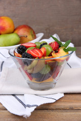 fresh tasty fruit salad on wooden table