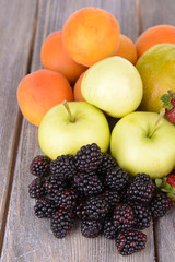 Naklejka na ściany i meble Ripe fruits and berries on wooden background