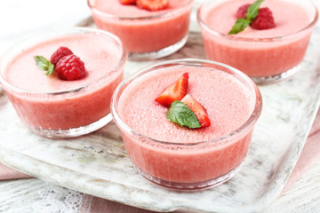 Delicious berry mousse in bowls on table close-up