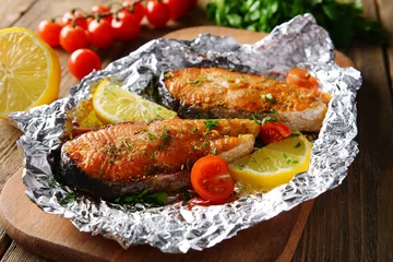  Tasty baked fish in foil on table close-up © Africa Studio