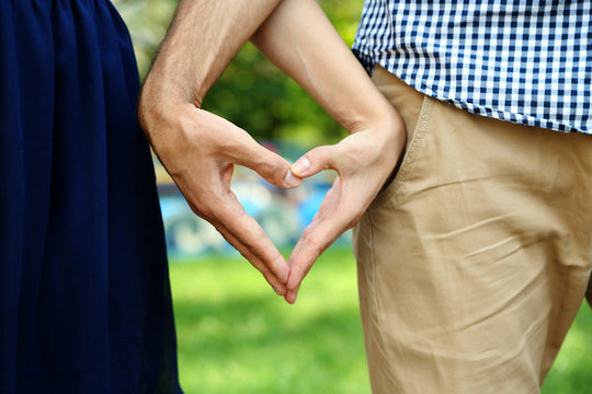 Young Couple In Love Make Heart