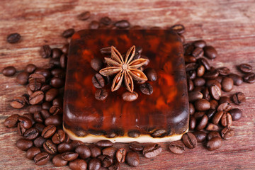 Organic soap with coffee beans and spices on wooden background