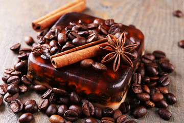 Organic soap with coffee beans and spices on wooden background