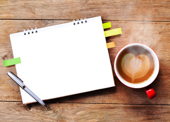 Hot coffee with blank paper note on wood background