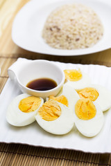 Boiled eggs with sauce and stream rice