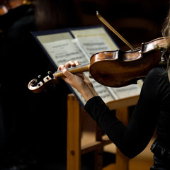 Violin in the hands of a girl in a symphony orchestra